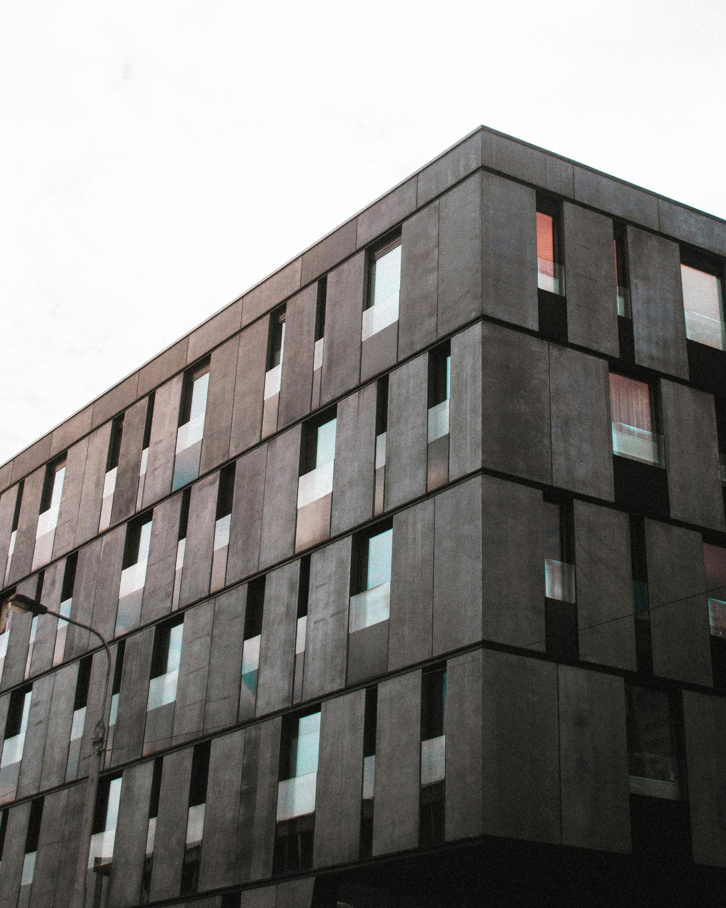Modern residential building with dark facade panels and narrow vertical windows.